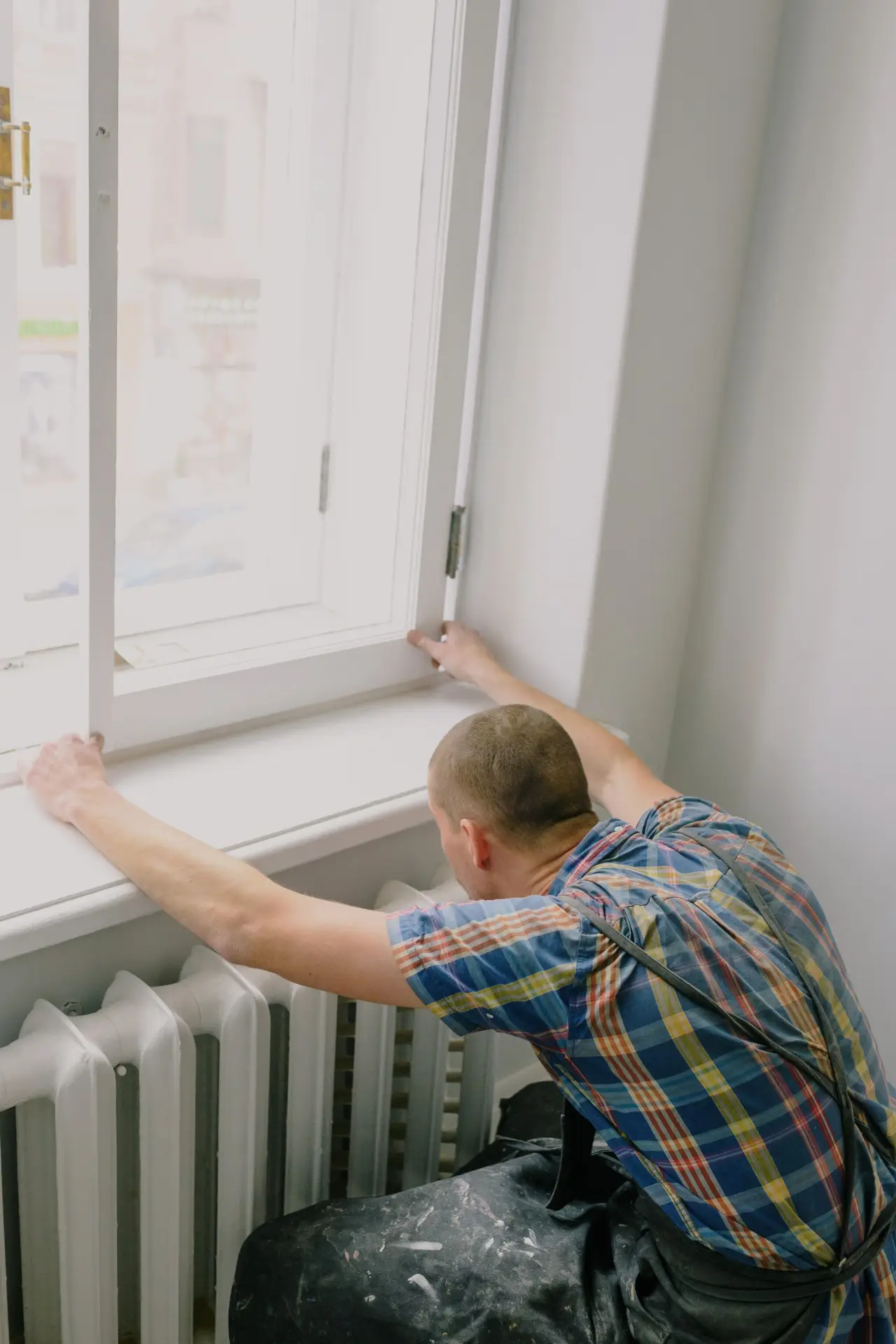 Szakember új ablakot épít be egy felújítás alatt álló szobában